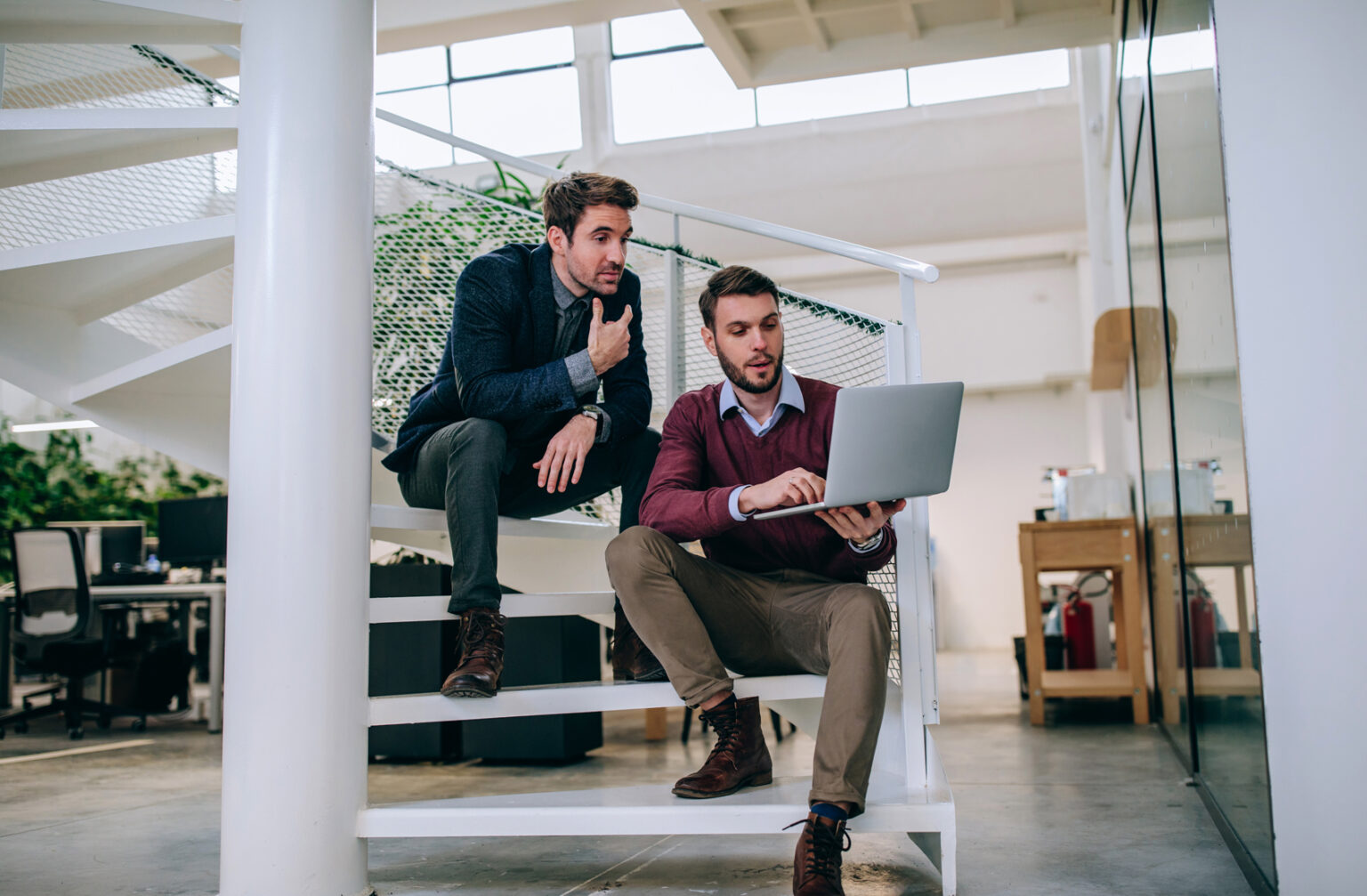 Two businessman sitting on the stairs talking